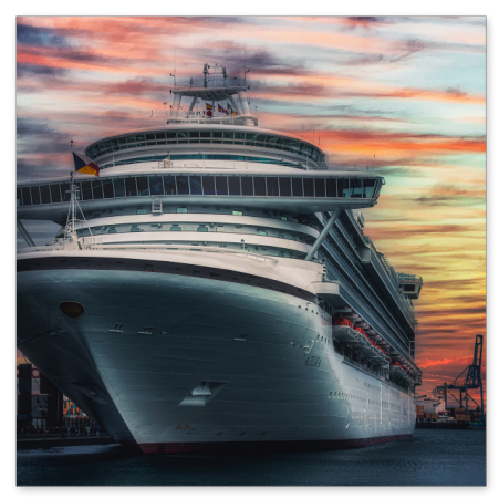 Die imposante Bugansicht des großen Kreuzfahrtschiffs Azura, das im Hafen liegt. Der dramatische Abendhimmel im Hintergrund leuchtet in kräftigen Orange-, Rot- und Blautönen.